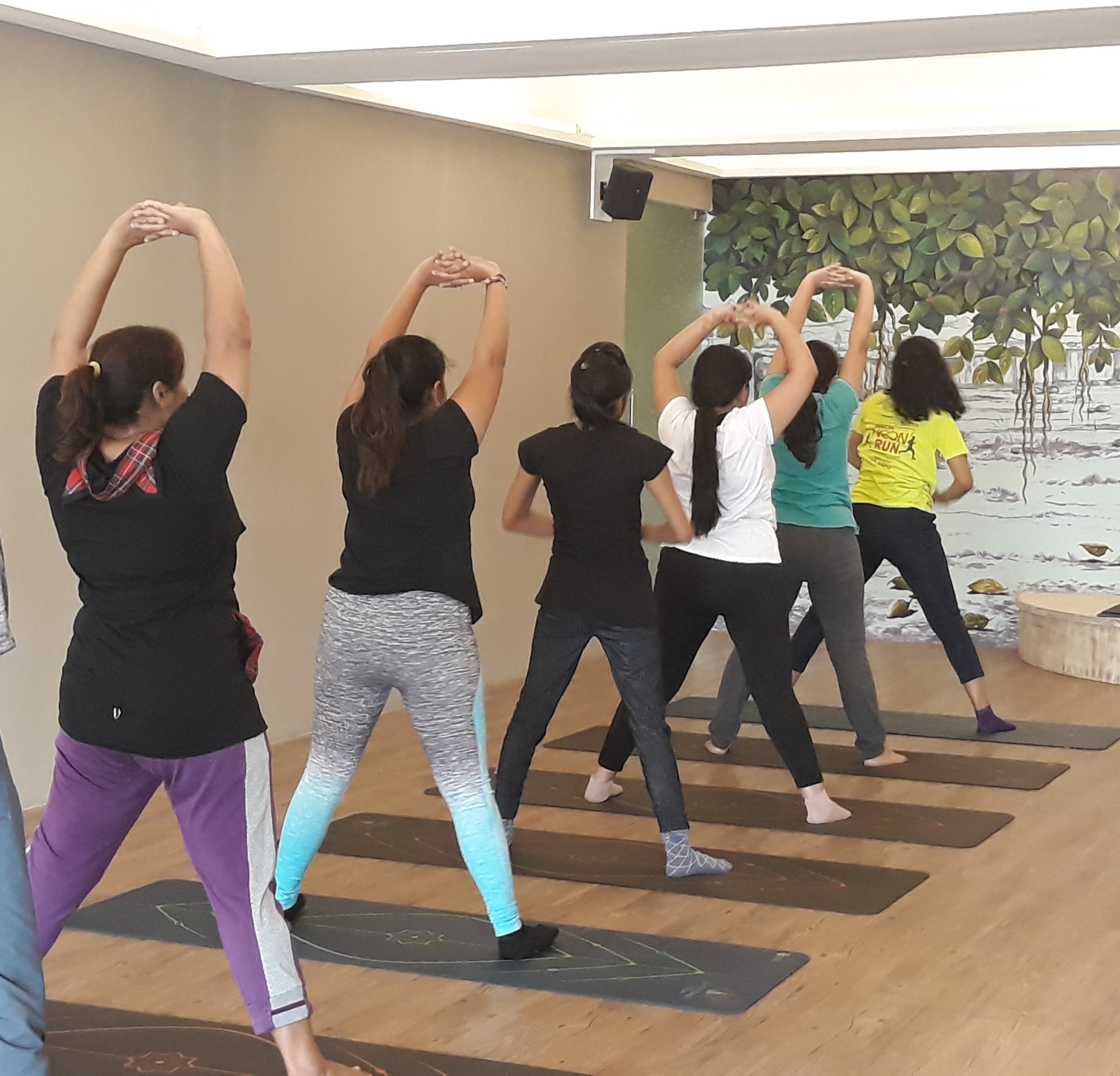Women practicing yoga together in a female-only batch